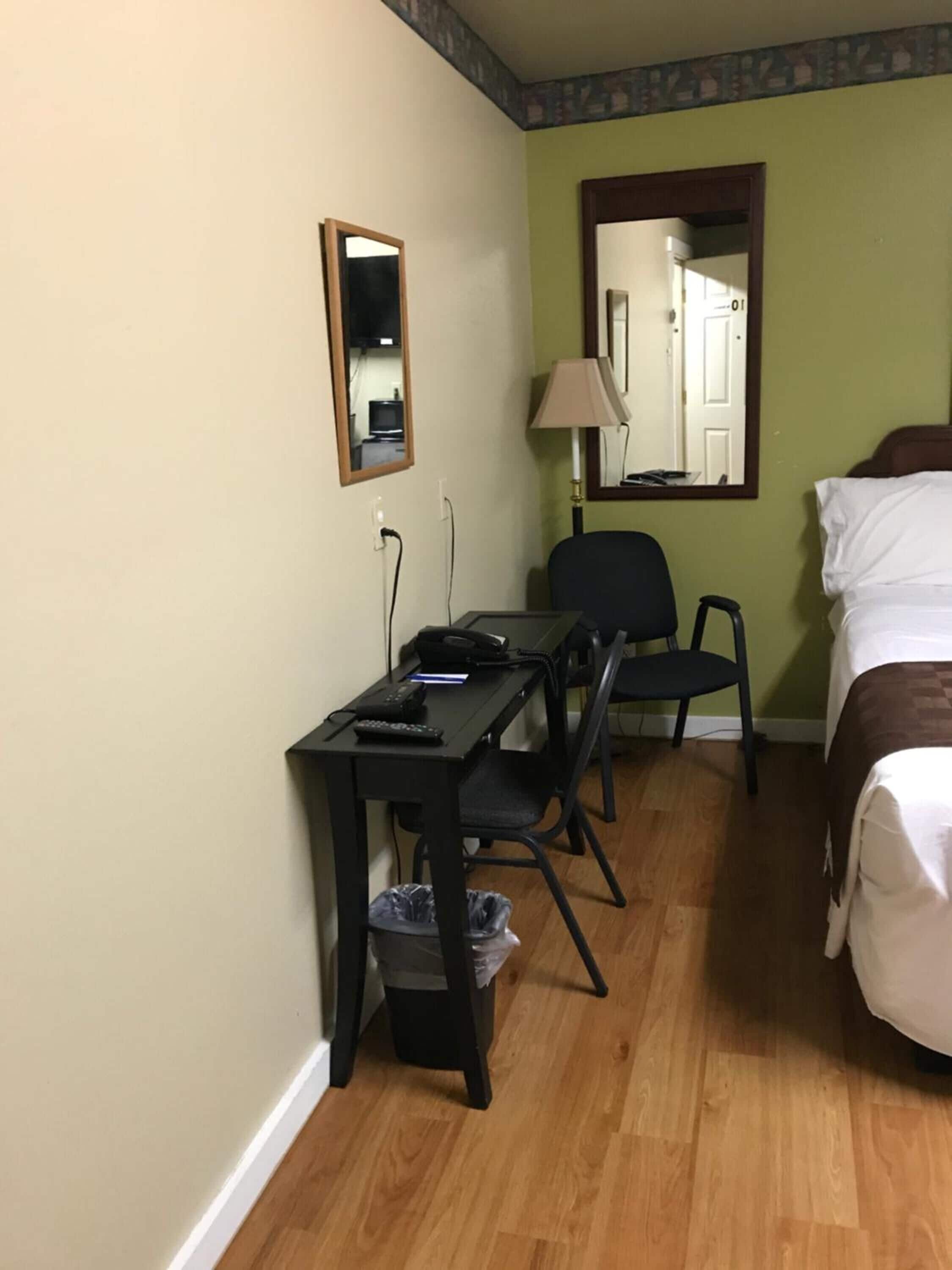 Une chambre d’hôtel équipée d’un bureau, d’une chaise et d’un lit.