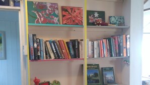 A bookshelf with various books and a few decorative items. - Pear Tree Farm (Glastonbury)