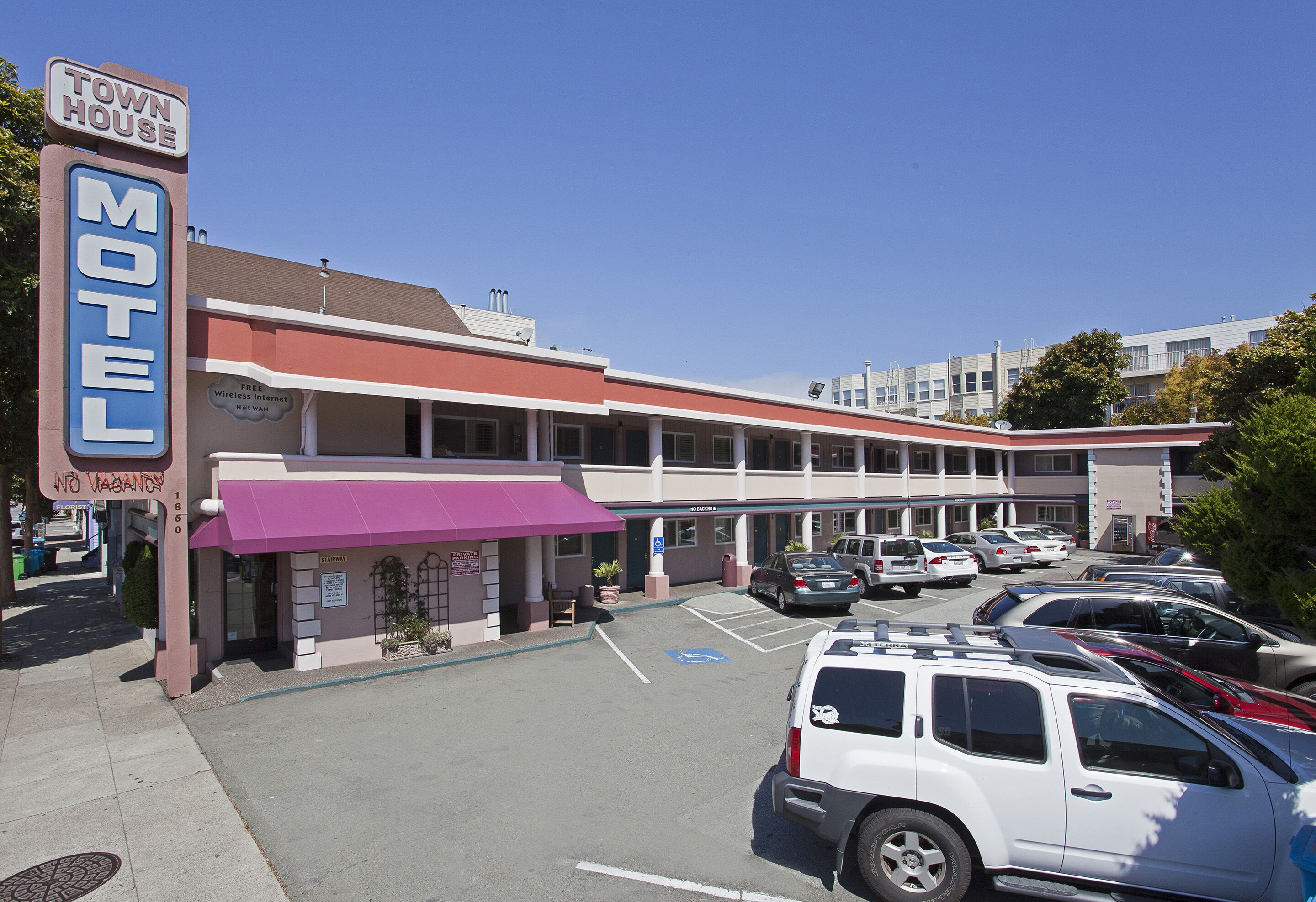 Un motel con aparcamiento y un cartel que indica internet inalámbrico gratuito.