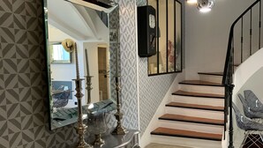 Eine Treppe mit modernem Design, ein Konsolentisch mit Dekoration und eine Wand mit Muster.