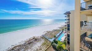 A beachfront hotel with a pool, balconies, and ocean views.