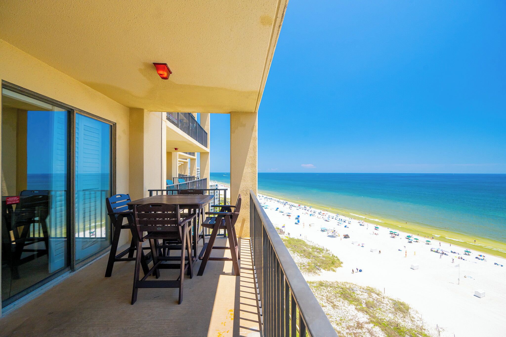 A balcony with a view of a beach and ocean.