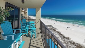 A balcony with turquoise chairs and tables overlooking a beach. - * 2 BR 2 BA * On the BEACH (Orange Beach)