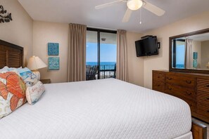 A bedroom with a large bed, a ceiling fan, a TV, and a view of the ocean. - 3 BR 2 BA Phoenix VII Condo 7708 (Orange Beach)