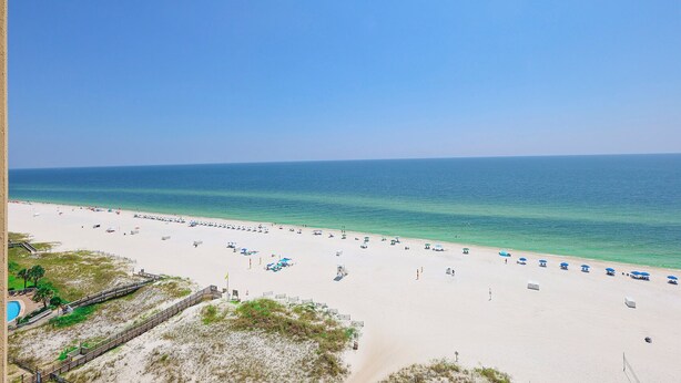 A beach with a wooden walkway leading to the water, clear skies, and a calm sea. - Two Bedroom Phoenix 5 Condo 1215 (Orange Beach)