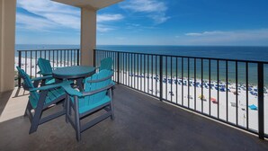 Un balcón con vistas a la playa, que incluye una mesa y sillas.