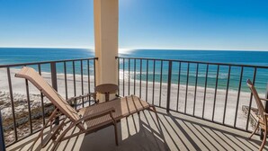 A balcony with a view of the beach and ocean.