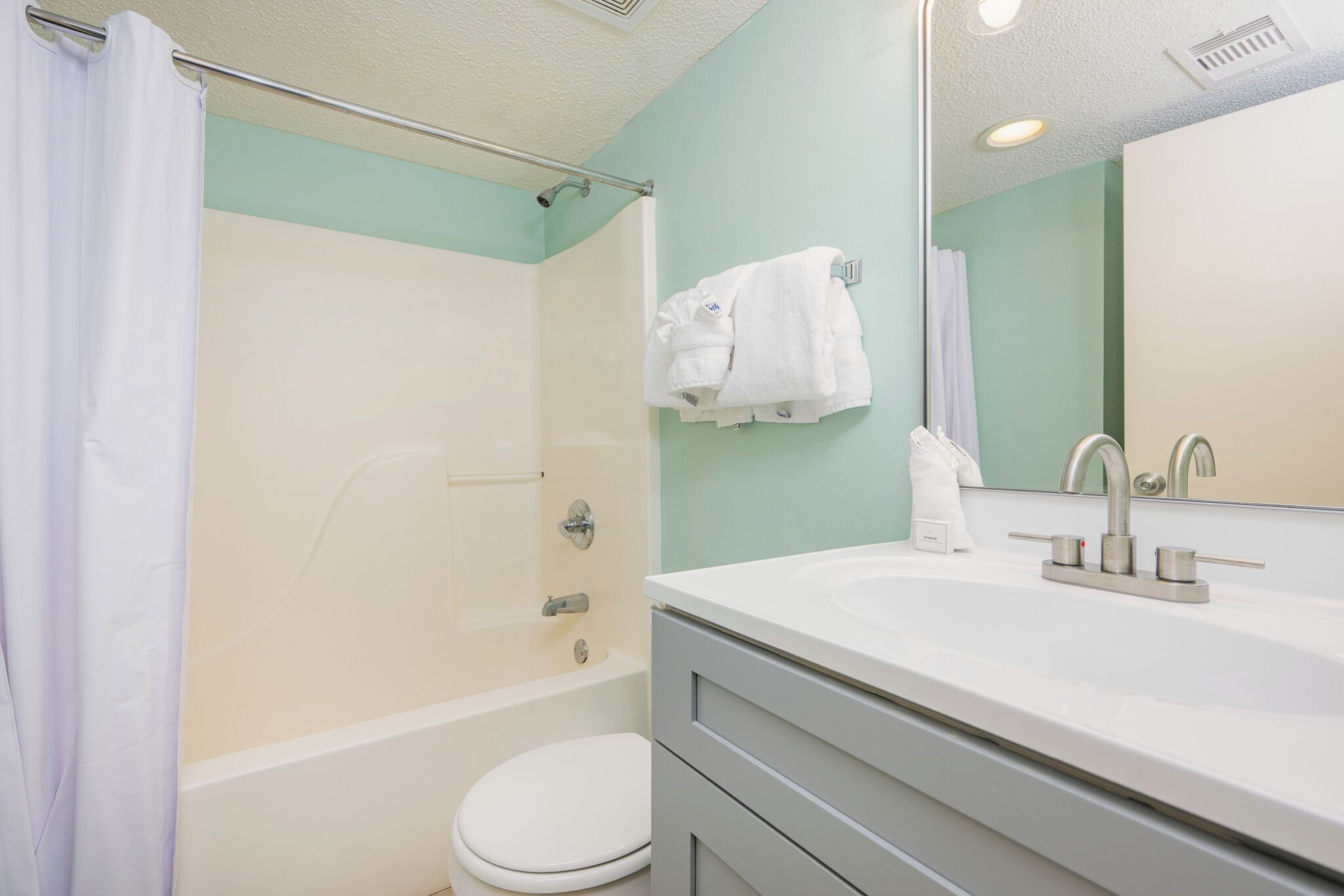 A bathroom with a bathtub, toilet, and sink.