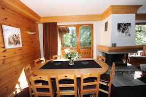 A wooden interior with a dining table, chairs, a fireplace, and artwork on the walls. - Superb duplex in luxury apartment at foot of slopes (Val-D'isère)