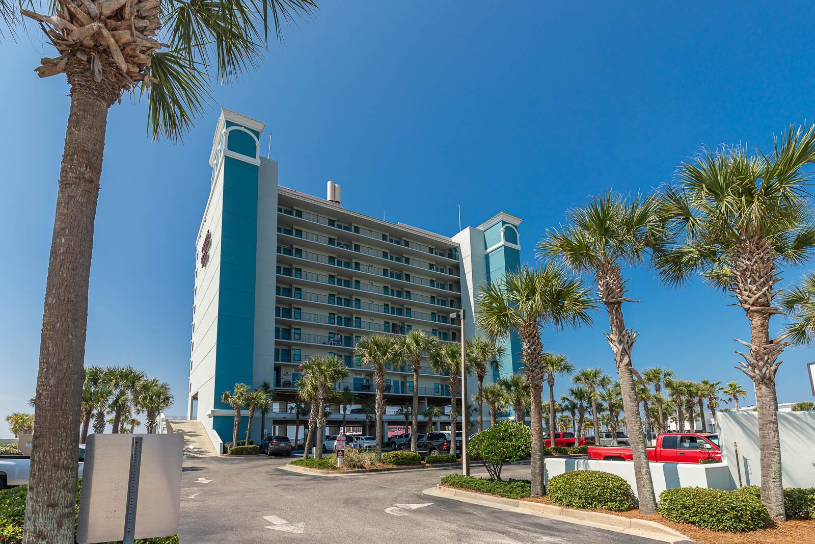 A multi-story hotel with a modern design, featuring a prominent tower and a series of balconies.
