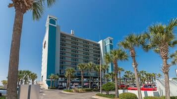 A multi-story hotel with a modern design, featuring a prominent tower and a series of balconies.