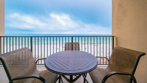 A balcony with a view of the beach, a round table, and two chairs. - 7th Floor! Two Bedroom - Balcony on the Beach! Phoenix X (Orange Beach)