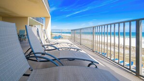 A balcony with lounge chairs, a view of the beach, and a clear sky. - PREMIUM 2 Bedroom @ P5 ~ Great Rates (Orange Beach)
