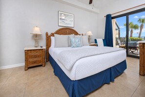 Una habitación de hotel con una cama grande, dos mesitas de noche, un ventanal con vistas y un cuadro en la pared.