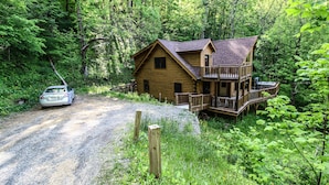 Een chalet met terras, omringd door dicht bos.
