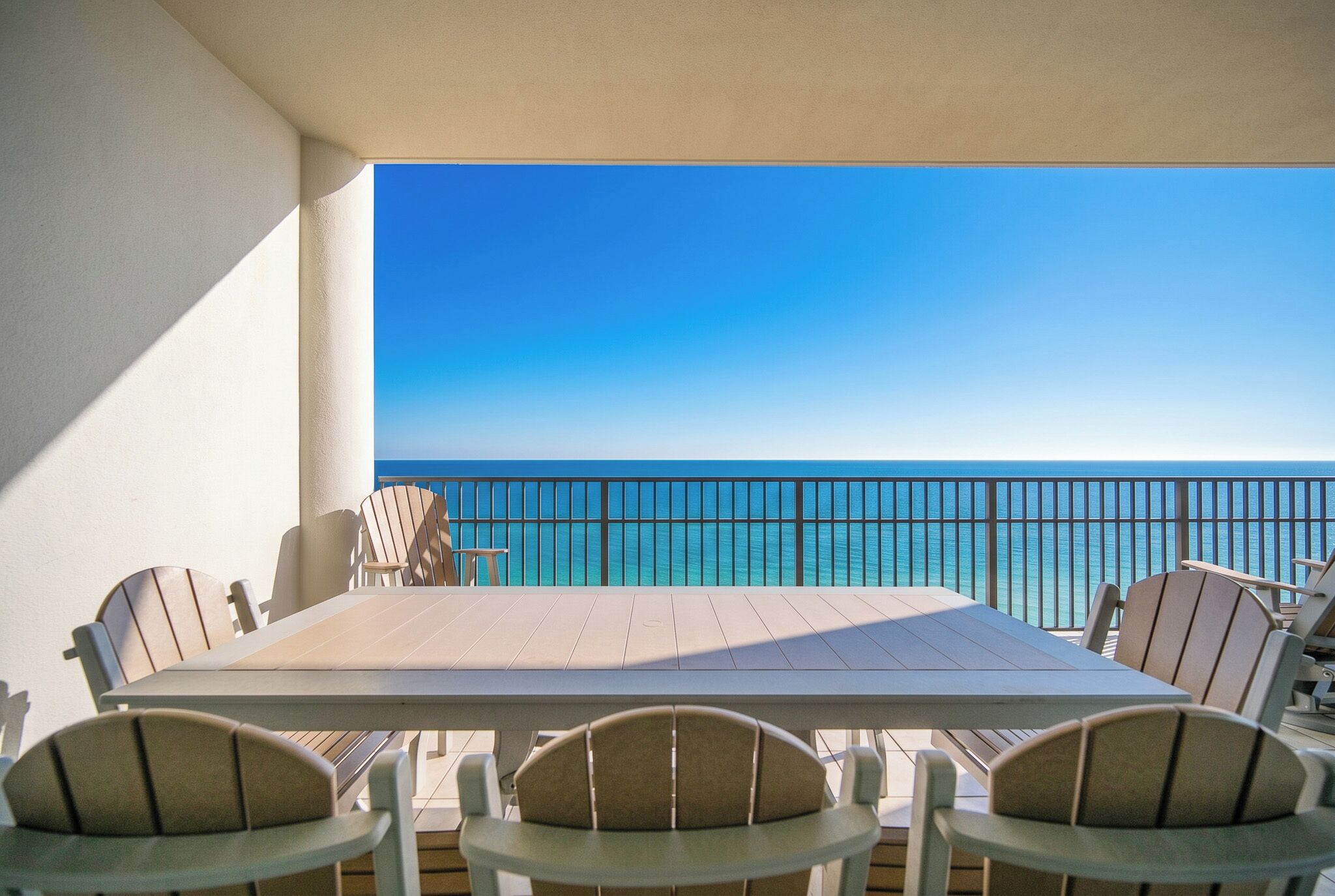 A terrace with a table and chairs, overlooking a body of water.