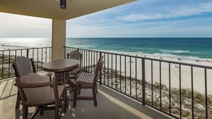 A balcony with a view of the beach and ocean.