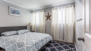 Un dormitorio con una cama, una decoración con estrellas y cortinas.