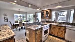 Una cocina moderna con encimeras de granito, armarios de madera y una isla central.
