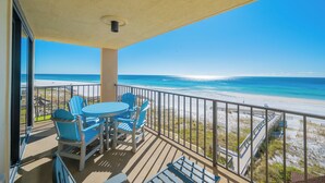 A balcony with a view of the beach, a table with chairs, and a railing. - 2 Bedroom BEACH FRONT! Phoenix I (Orange Beach)