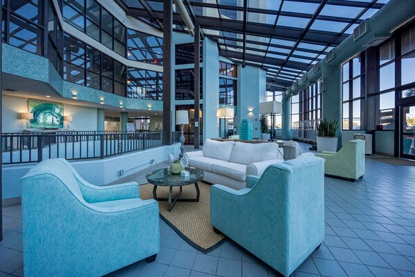 Relax in our spacious lobby with a high ceiling and open-plan layout, featuring a seating area with sofas and armchairs.