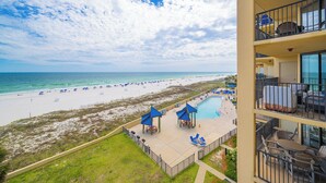 Un hôtel doté d'une piscine, offrant une vue sur la plage et disposant d'un espace extérieur aménagé pour s'asseoir.