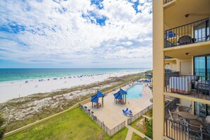 A hotel with a pool, beach view, and outdoor seating area. - Three Bedroom on the 4th Floor…Comes with Reserved Parking (Orange Beach)