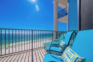 A balcony with blue chairs and a view of the beach. - The Oasis of Orange Beach 1010 (Orange Beach)