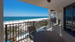A balcony with a view of a beach and ocean.