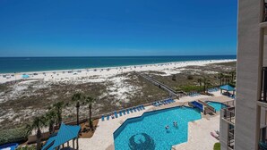 A pool area with a view of the beach and ocean.