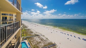A beachfront hotel with a pool, beach umbrellas, and a clear view of the ocean. - GREAT BEACH FRONT VIEW from this 2 Bedroom at Phoenix 3 (Orange Beach)