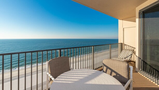 A balcony with a view of the ocean, a chair, and a small table. - The Gulf, the Sun, the View 2 bedroom Phoenix X 1216 (Orange Beach)