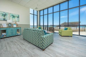 Enjoy a room with a large window offering a view of the beach and a building in the distance.