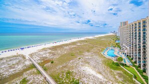 A beach resort with a long pier, a pool area, and a beachfront.