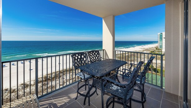 Un balcon avec vue sur la plage et l’océan.