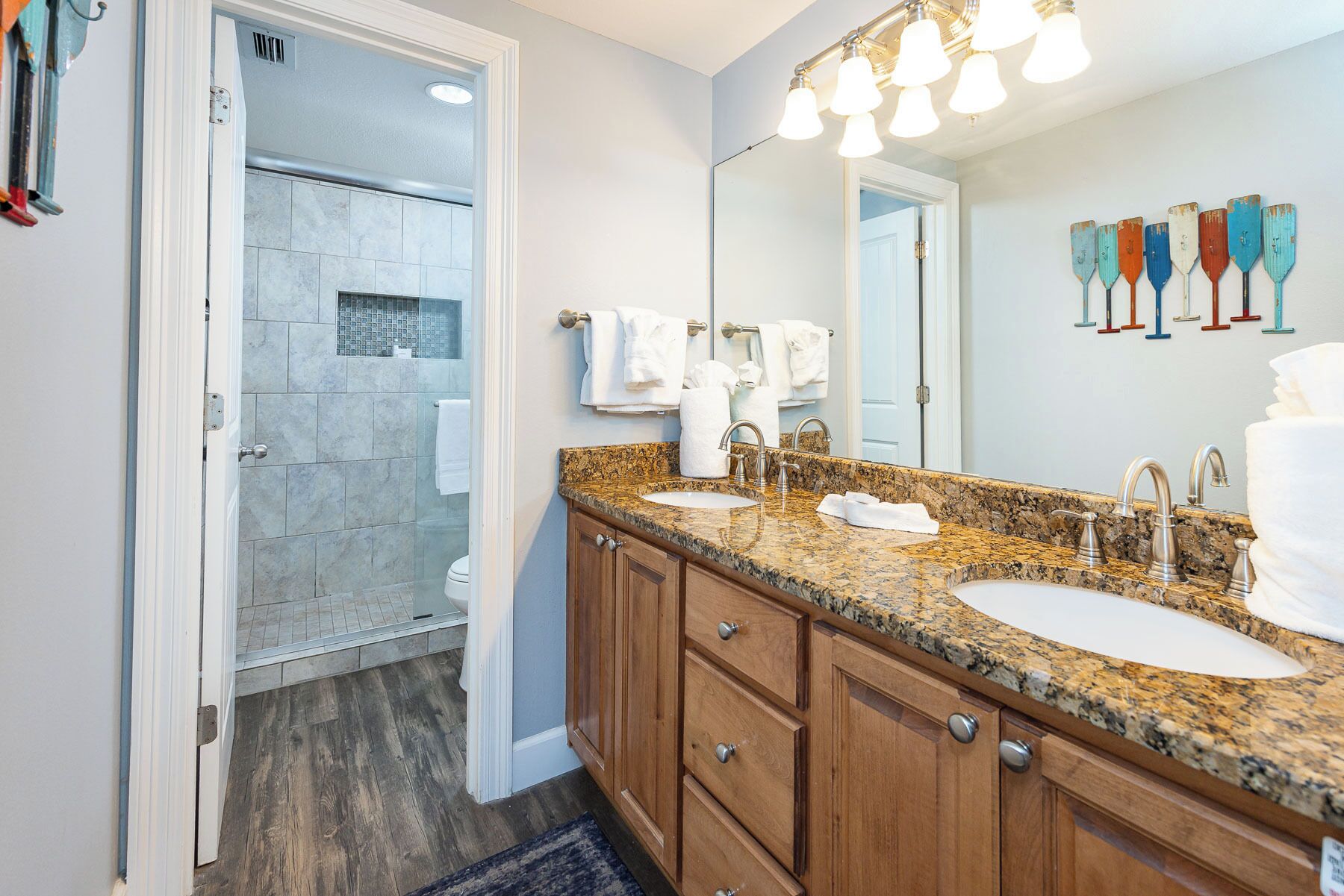 A bathroom with two sinks, a large mirror, and a shower area.