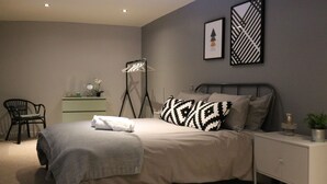 Une chambre à coucher avec un lit, une table de chevet et une chaise.
