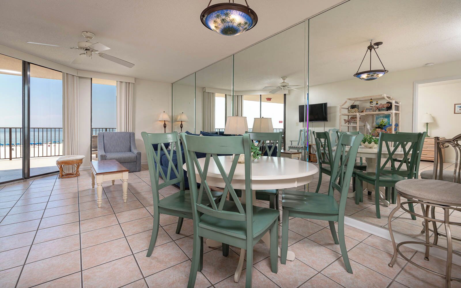 Un vaste espace de vie avec balcon, une table à manger avec des chaises et un téléviseur.