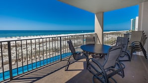 A balcony with a view of the beach and ocean.