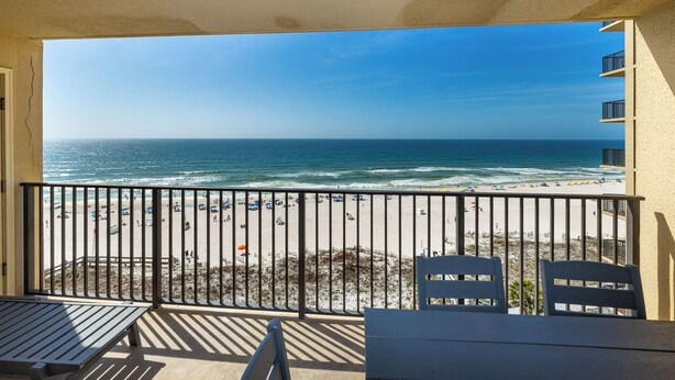 A balcony with a view of a beach and ocean.