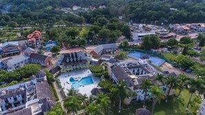 An aerial view of a resort with a swimming pool, multiple buildings, and lush greenery. - Sunkissed Suites at Sandcastles (Ocho Rios)