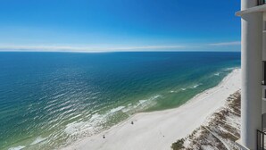 A beach with clear blue water and a sandy shore. - The Oasis at Orange Beach, formerly known as Phoenix West II, Unit 3006 (Orange Beach)