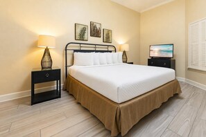 A neatly arranged hotel room with a bed, two bedside tables, a television, and wall art. - The Oasis at Orange Beach, formerly known as Phoenix West II, Unit 3006 (Orange Beach)