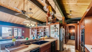 A spacious kitchen with wooden cabinets, a large island, and a built-in oven. - The Tulip Tree Bay Lodge (Sparta)