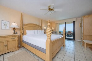 A four-poster bed with a ceiling fan, a balcony with outdoor furniture, and a wooden cabinet with a lamp. - Low Floor 3BR with Rsvd Parking @ Phoenix VII (Orange Beach)