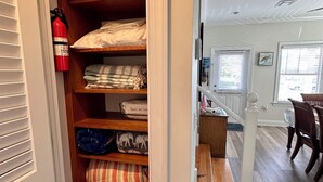 A closet with shelves, a fire extinguisher, and a small table.