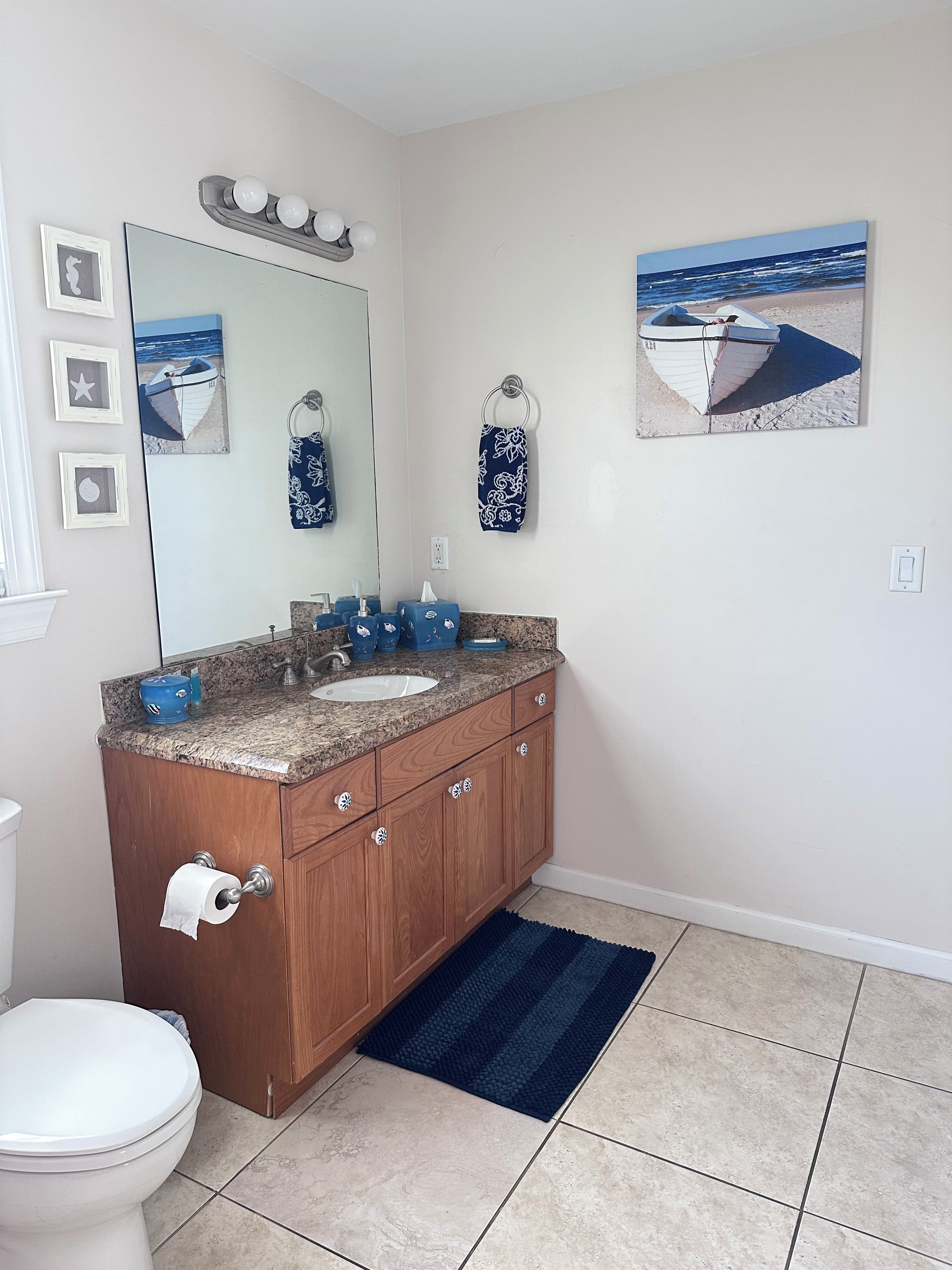 A bathroom with a toilet, sink, and wooden vanity.