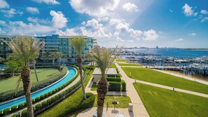 Een resort met een zwembad, palmbomen en een jachthaven.