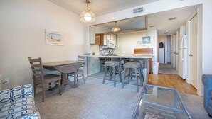 A compact living space with a dining area, kitchen, and a small seating area.