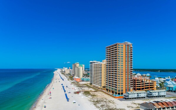 A coastal hotel with a beach view, multiple floors, and a parking structure. - **WEEKLY SPECIALS!** Phoenix Gulf Shores - 6th Floor - 3 BR 3BA (Gulf Shores)
